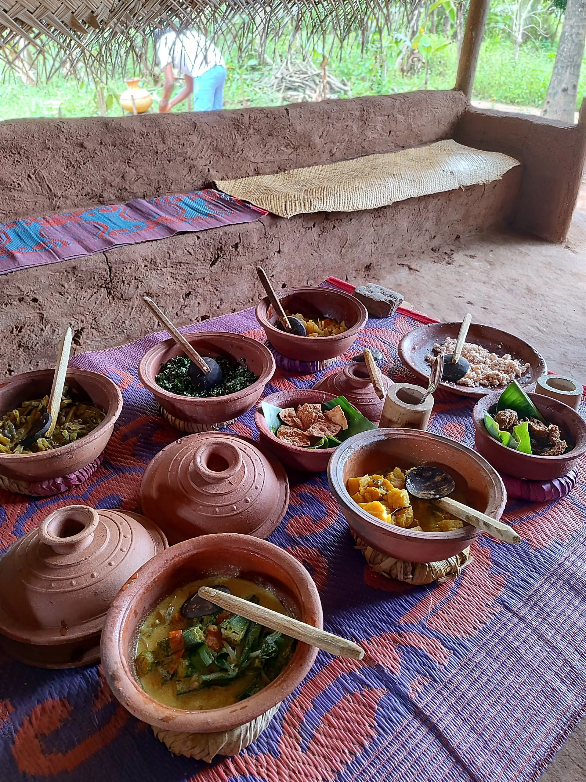 A rice and curry meal served in clay bowls in a roadside shelter
