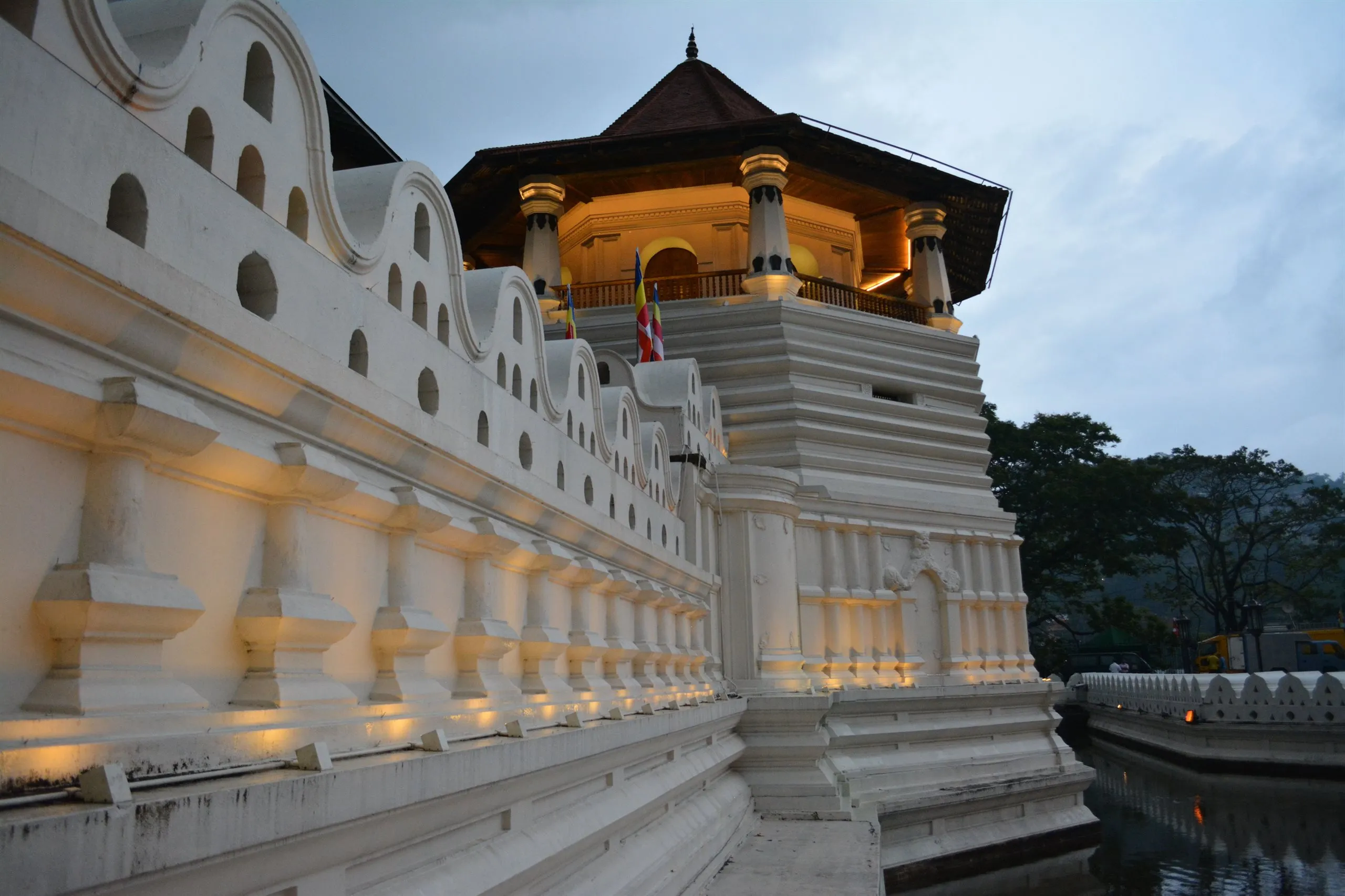The Temple of the Sacred Tooth Relic in Kandy reflected in the lake at dusk